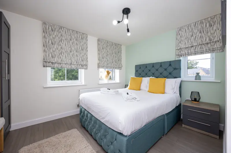 Bedroom 2 with a double bed and teal headboard